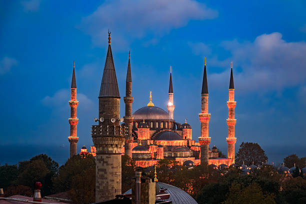 A sunset view of the famous Sultanahmet Mosque or Blue Mosque with six minarets and multiple domes, beautifully illuminated in Istanbul, Turkey