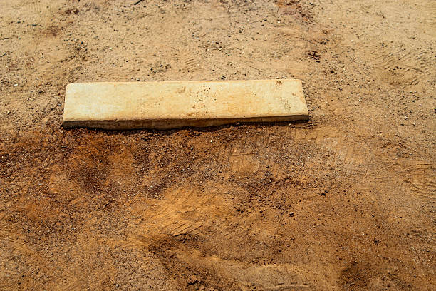 istock looking down at a baseball pitcher's mound and dirt with texture in the middle of summer. 2229444669