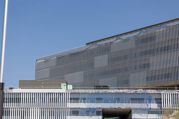 istock Modern hospital building undergoing renovation with scaffolding and debris netting 2229449162