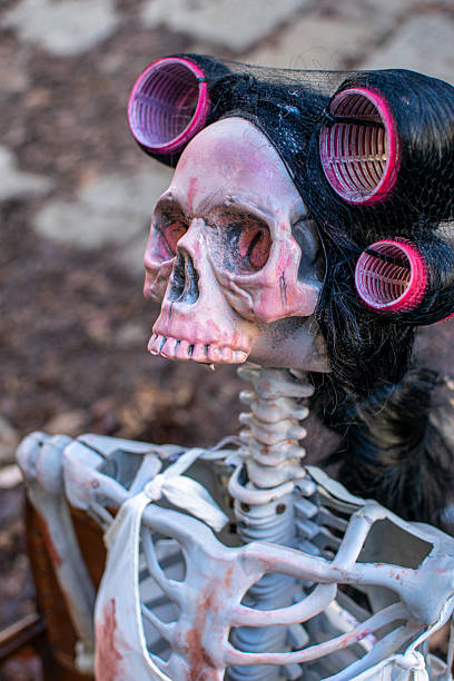 Skull with blonde hair on pastel pink backround.Creative Halloween minimal concept
