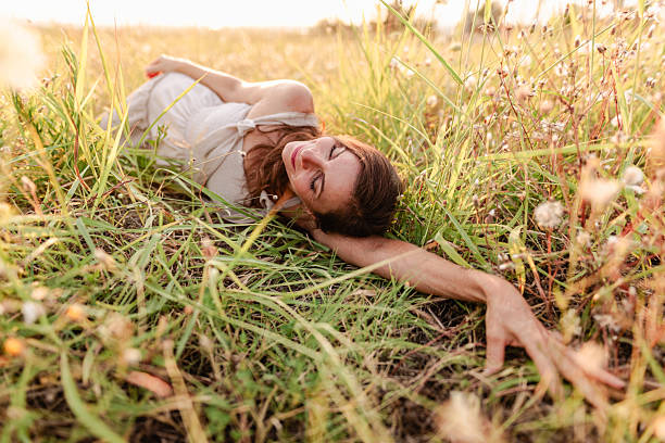 istock Relaxed Woman Lying in Grass During a Serene Summer Daytime Outd 2229454343