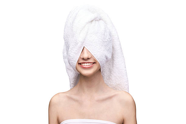 istock Young caucasian female with towel wrapped around head smiling, white background 2229457761