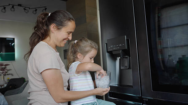 istock Smart Refrigerator. Mom & Kid Fill Ice Cubes From Ice Maker 2229458322
