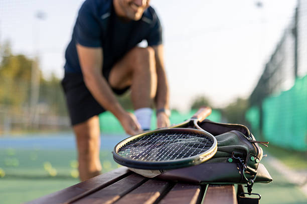 istock Tennis racket rests on bench while player ties shoes nearby 2229459100