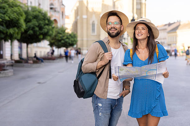 istock Couple tourists navigating city with map under sunny skies. 2229459198