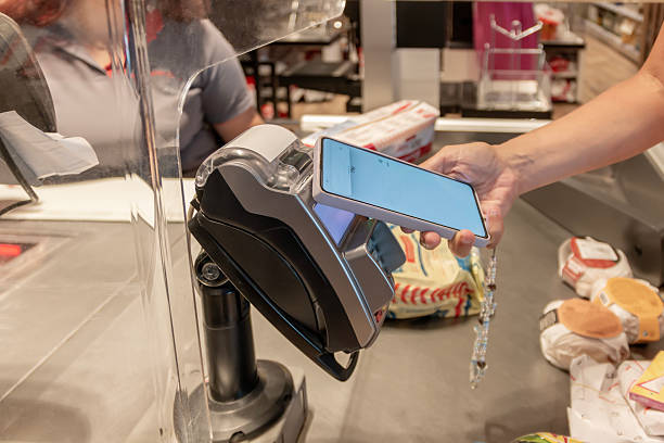 istock A woman using her mobile phone for contactless payment while holding it over electronic machine. 2229462800