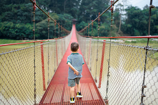 Little boy crossing the rope bridge