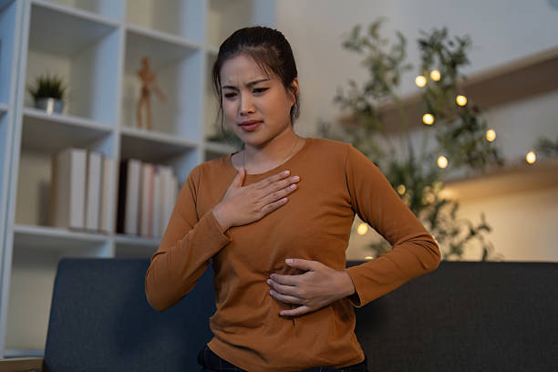istock Health Awareness: Young woman experiencing abdominal pain while seated 2229469454