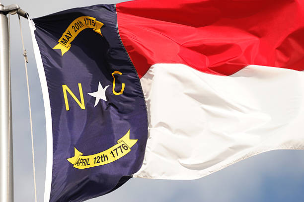 istock North Carolina State flag waving under sky 2229471265