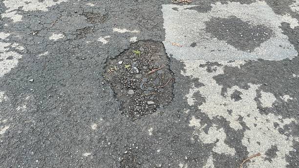 istock Pothole in asphalt showing damage and exposed aggregate material 2229471786