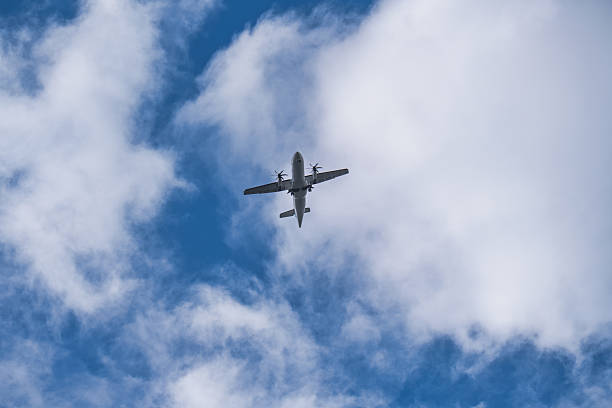 istock Turboprop Airplane Flying Over Blue Sky with White Clouds 2229474365