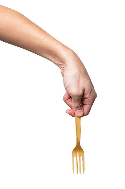 istock Male hand holding a gold plastic fork isolated on white background. 2229476407
