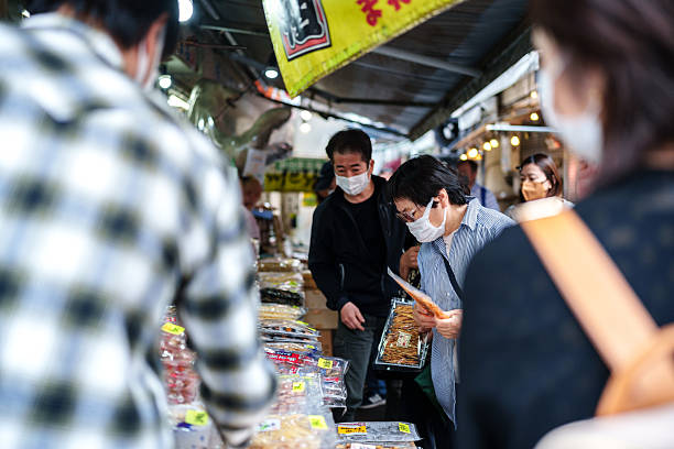 Tokyo, Japan - May, 29, 2023: People buying food in Tokyo. Food stalls are popular in Japan, selling a variety of traditional and modern cuisine, attracting tourists from all around the world.
