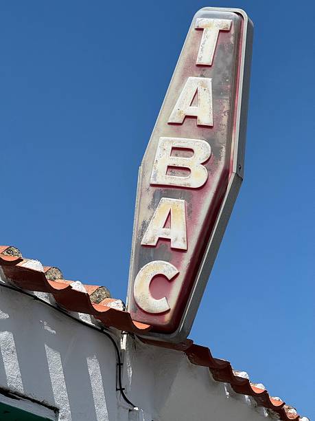 istock Vintage 'Tabac' sign on a white building against a clear blue sky, showcasing retro typography 2229478414