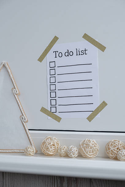 istock TO DO LIST checklist text on paper note stick on while wall with cozy minimalistic handmade Christmas decor. New year aims resolutions. Low key festive Planning and setting goals 2229478626