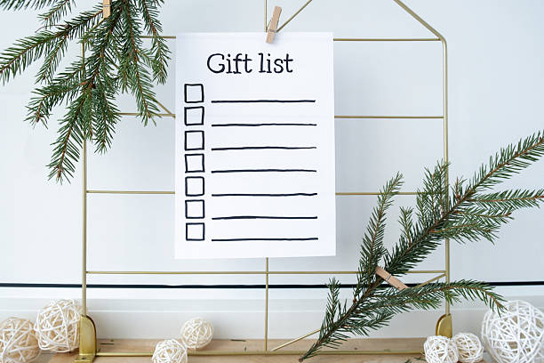 istock Holiday preparation paper note with GIFT LIST checklist text. Vision board with cozy minimalistic handmade new year Christmas decor Low key festive celebration 2229479150