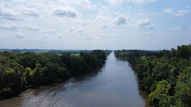 istock Serene river flowing through lush green forests under a partly cloudy sky 2229480033