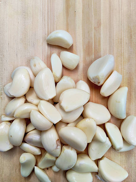istock Close Up Fresh Garlic Cloves on a Wooden Surface 2229480833