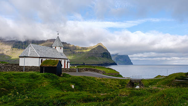 istock Scenic coastal view featuring a charming church in the Faroe Islands with dramatic cliffs 2229493338