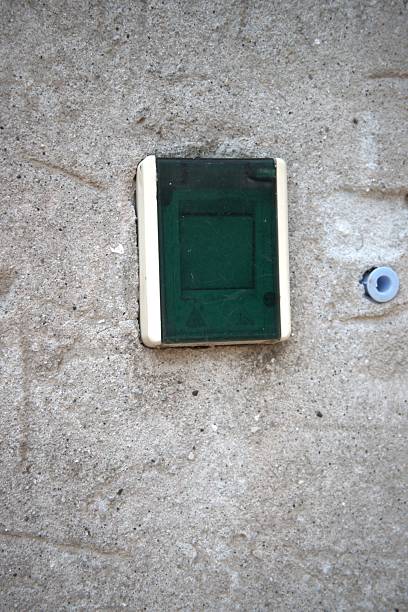 Gold coloured light switch on a hallway wall by the stairs