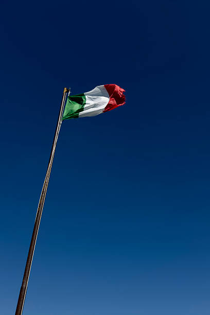 istock Italian flag waving in a strong wind against a blue sky 2229495943