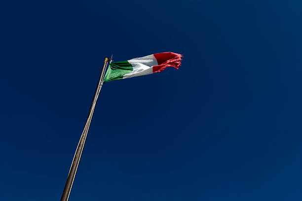 istock Italian flag waving in a strong wind against a blue sky 2229495950