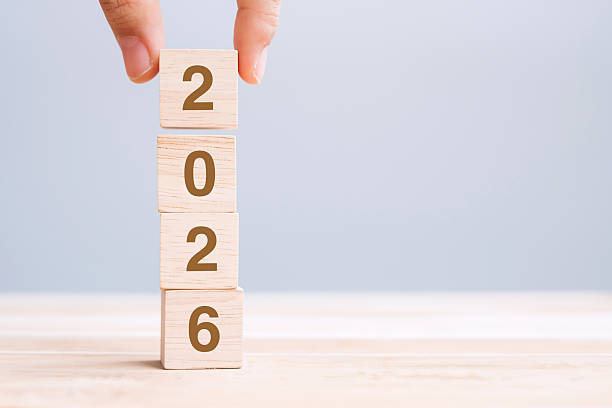 istock hand holding wooden cube block with 2026 text on table background. Resolution, plan, review, goal, start and New Year holiday concepts 2229496619