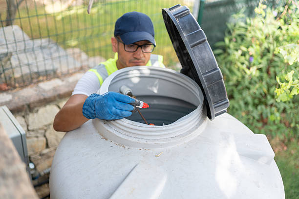 istock Plumber Pouring Liquid Into Water Storage Tank 2229499479