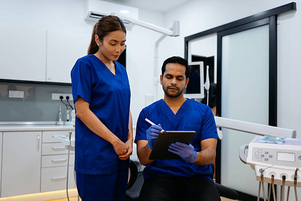 istock Dental Professionals Reviewing Patient Records on Digital Tablet 2229500792