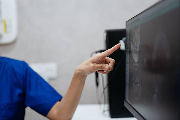istock Close up dentist's hand pointing and explaining X-ray results to patient 2229501373