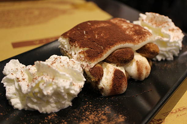 African American female hands cutting a Tiramisu cake.
