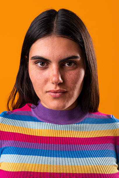 istock Young woman with freckles posing in studio with orange background 2229504575