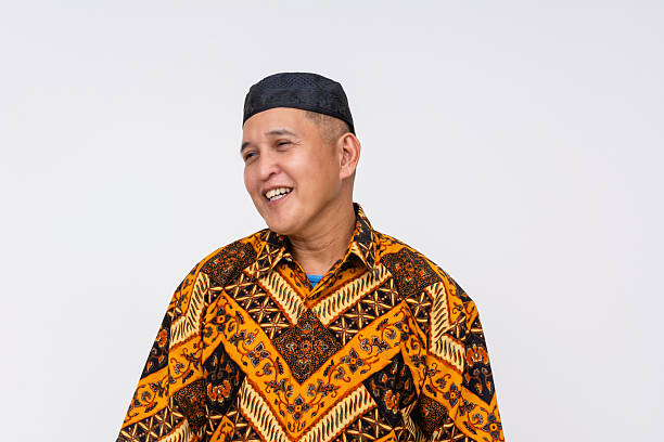 istock A cheerful Indonesian man wearing a patterned batik shirt and a songkok, representing traditional culture and attire. 2229504992