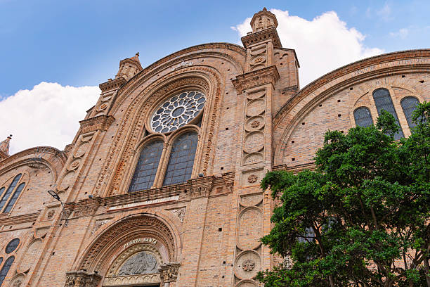 Detail of the Holy Door and facade of Cuenca Cathedral, Ecuador, captured from a low angle under a blue sky.