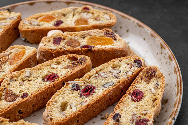 istock Italian Almond Biscotti biscuits in a rustic home made pottery bowl. Studded with almonds and cranberries, these twice-baked treats are aromatic and inviting. Ideal. 2229512557