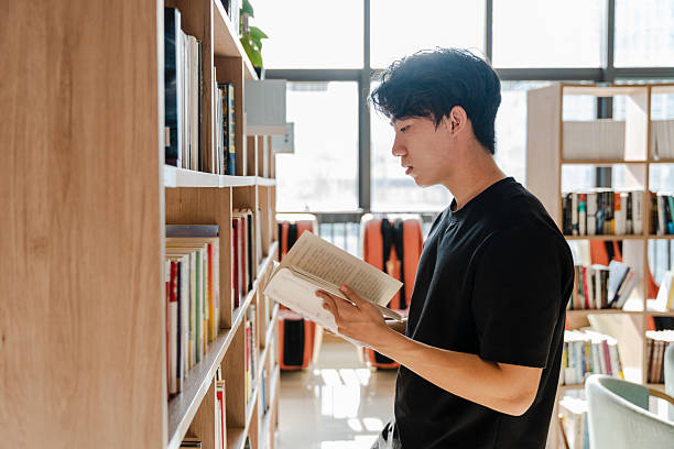 istock Asian college students studying and searching for books in library 2229513811