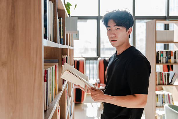 istock Asian college students studying and searching for books in library 2229513813