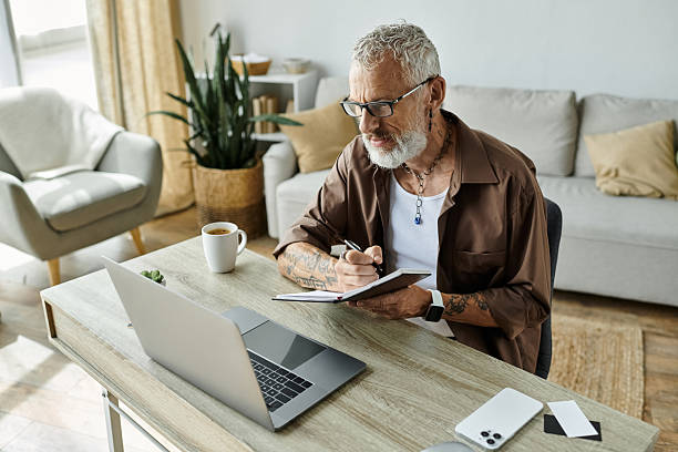 istock Senior man engages in creative writing while enjoying a cup of coffee at a cozy workspace 2229519594