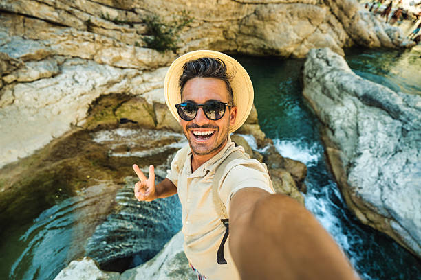 istock Happy man taking selfie on jungle river background - Smiling hiker having fun on adventure trip - Technology life style concept 2229521177