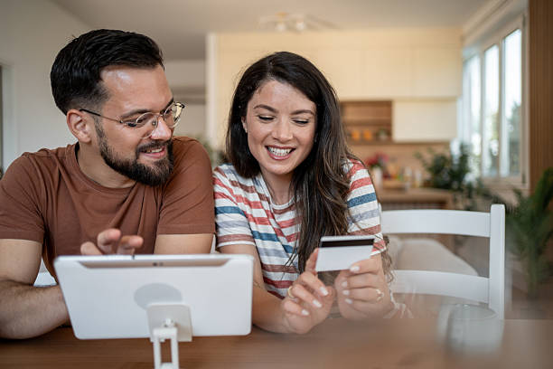 istock Happy couple making online payment using digital tablet and credit card at home 2229523972