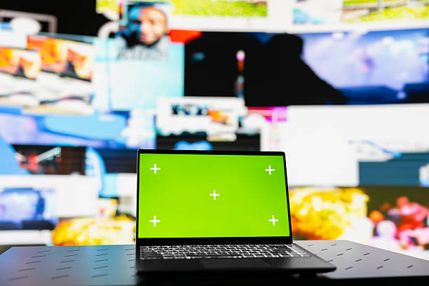 Laptop showcasing display with green screen mockup next to modern web design