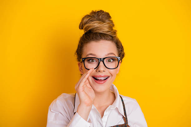 istock Happy student with glasses excitedly expressing a joyful gesture against a vibrant yellow background 2229524343