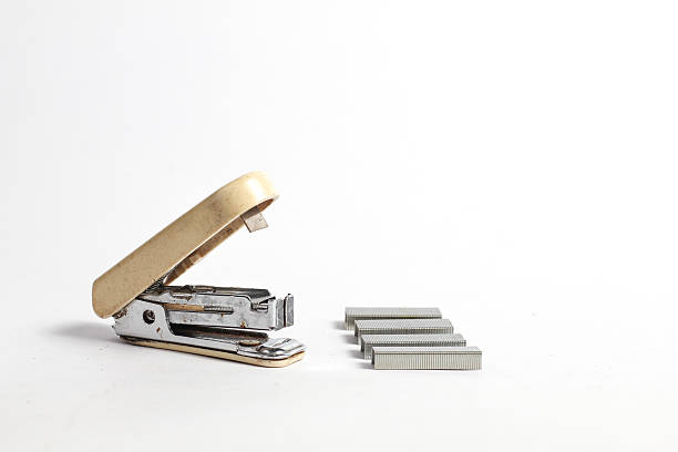 Stapler tool with multiple metal staple refills scattered around.