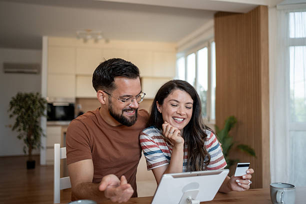 istock Happy couple making online payment using digital tablet and credit card at home 2229526201