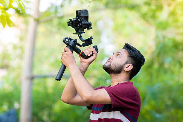 Videographer exploring nature and filming with camera and stabilizer gimbal in nature.