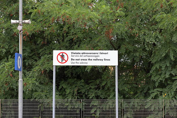 istock Sign on a railway station platform indicating that crossing the tracks is prohibited due to the danger of an approaching train 2229526654