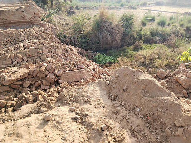 Demolished Old Bridge with Scattered Bricks and Earth Preparing for New Construction Reflecting Rural Development and Modern Engineering Under Open Sky with Vegetation and Future Infrastructure Plans