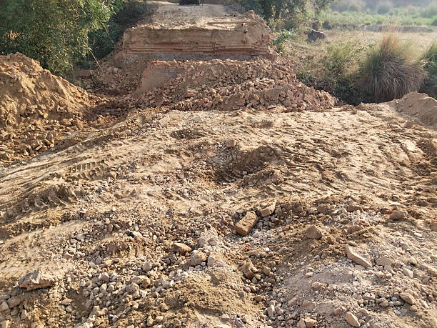 istock Demolished Old Bridge with Scattered Bricks and Earth Preparing for New Construction Reflecting Rural Development and Modern Engineering Under Open Sky with Vegetation and Future Infrastructure Plans 2229529834