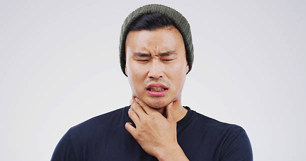 istock Studio, choke or Asian man with throat pain for cold, flu or virus symptoms on white background. Space, sick or male person isolated with uncomfortable sore neck, thyroid inflammation or asthma risk 2229534372