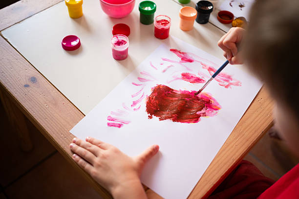 istock Young child engaged in creative painting activity at home with daylight 2229534501